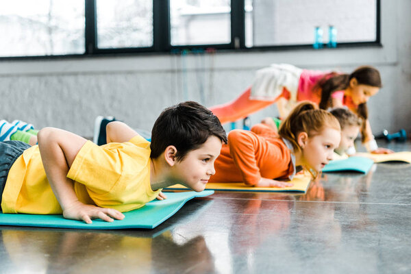 Preteen kids doing push-up exercise in gym