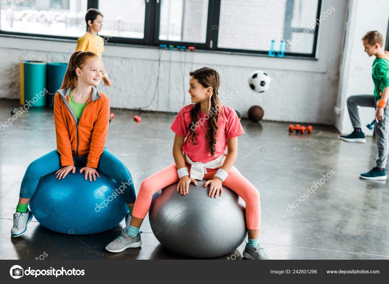 Kids Talking While Sitting Fitness Balls Stock Photo by