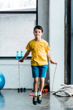 Sarı tişört atlama ip atlama ile içinde esmer çocuk