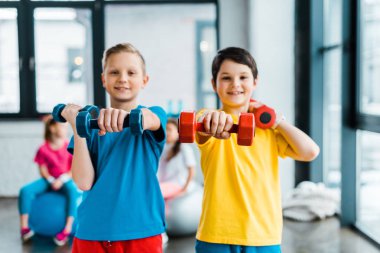 Egzersiz dumbbells ile birlikte yaptığı heyecanlı çocuklar