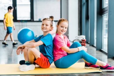 Çok güzel çocuklar arka arkaya fitness mindere oturmuş
