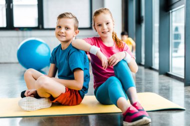 Spor salonunda fitness mat oturan varoluş arkadaşlar
