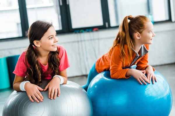 Niños Alegres Tumbados Pelotas Fitness Gimnasio Mirando Hacia Otro Lado —  Fotos de Stock