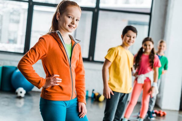Smiling preteen children posing in gym together