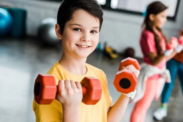 Glad Brunett Pojke Håller Röda Hantlar Gymmet — Stockfoto