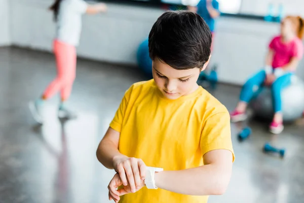 Boy Yellow Shirt Looking Smartwatch — Stok Foto