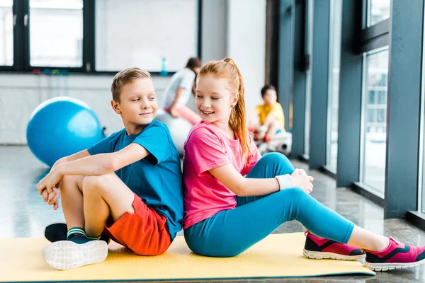 Duas Crianças Sentadas Costas Para Trás Tapete Fitness — Fotografia de Stock