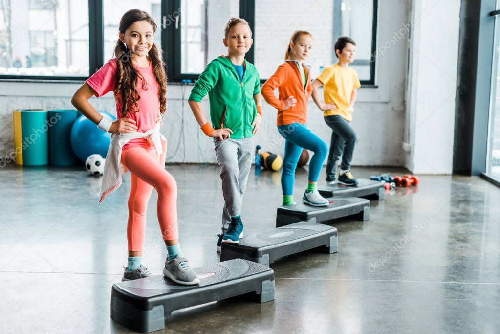 Group of kids using step platforms in gym