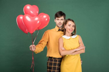 yeşil izole kamera bakarak kalp şeklinde balonlu güzel çift