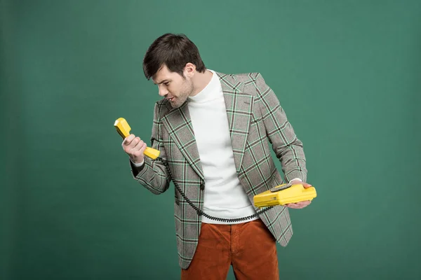 Dissatisfied Handsome Man Vintage Clothes Looking Retro Telephone Isolated Green — Stock Photo, Image