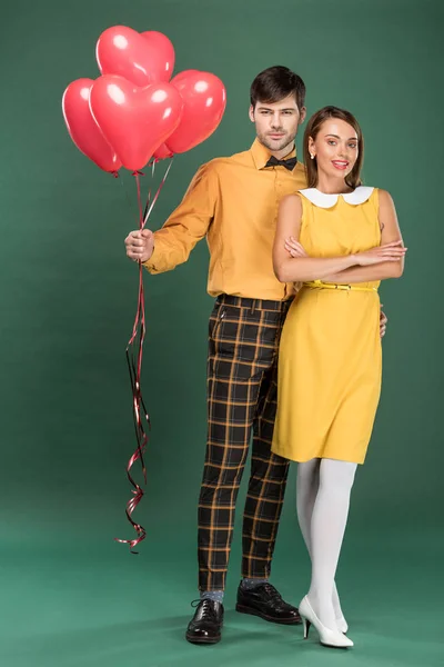 Beautiful Couple Heart Shaped Balloons Looking Camera Green Background — Stock Photo, Image