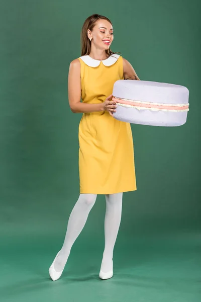 Vackra Leende Kvinna Som Håller Macaroon Modell Grön Bakgrund — Stockfoto