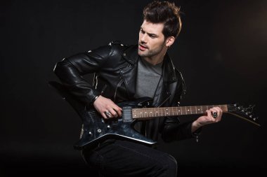 elektro gitar çalmak ve dış saha üzerinde izole siyah görünümlü deri ceketli yakışıklı rocker