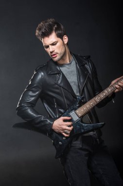 deri ceketli siyah izole elektro gitar çalmak yakışıklı rocker