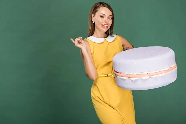 Hermosa Mujer Sonriente Señalando Con Dedo Sosteniendo Modelo Macarrón Aislado — Foto de Stock