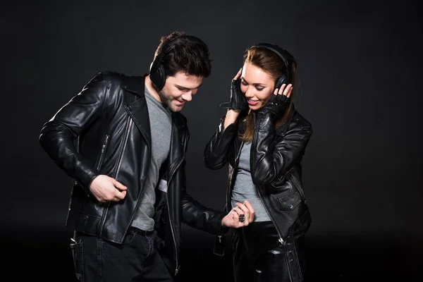 Hermosa Pareja Auriculares Chaquetas Cuero Escuchando Música Aislada Negro — Foto de Stock