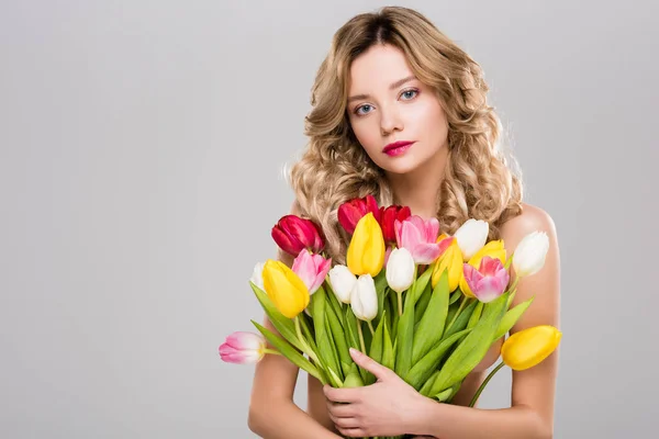 グレーに分離されたカラフルなチューリップの花束を保持している魅力的なばねの若い女性 — ストック写真