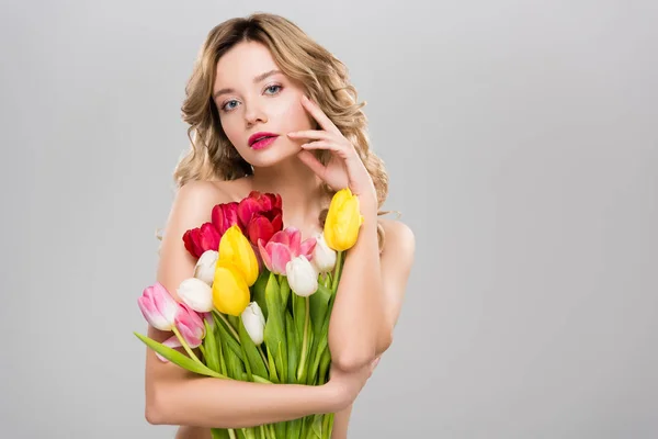 年轻美丽的裸体春天的女人摆姿势与郁金香花束隔离在灰色 — 图库照片