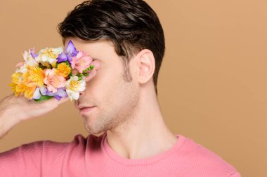 yüz alstroemeria çiçekli yandan kapsayan adam üzerinde bej izole
