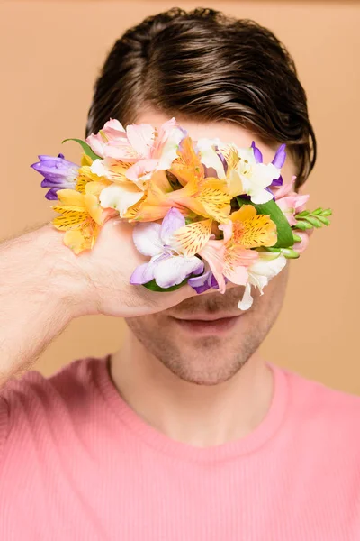 Homem Sorridente Cobrindo Rosto Com Flores Alstroemeria Mão Isolado Bege — Fotografia de Stock