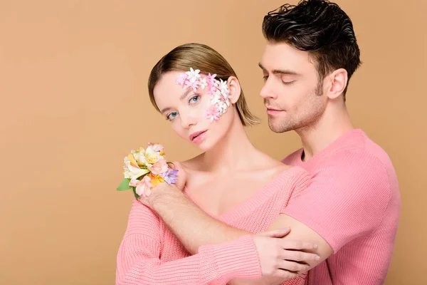 Yakışıklı Adam Kucaklama Kız Arkadaşıyla Üzerinde Bej Izole Yüzünde Çiçek — Stok fotoğraf