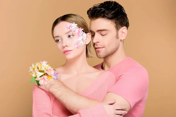 Guapo Hombre Abrazando Atractiva Novia Con Flores Cara Aislado Beige — Foto de Stock