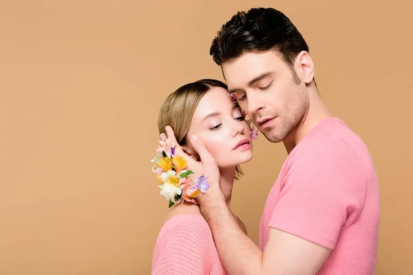 温柔的男人与在手上的星形花触摸在米色上孤立的有吸引力的女朋友的脸 — 图库照片