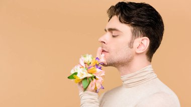 yan görüntülemek alstroemeria çiçekli yakışıklı adamın yandan üzerinde bej izole gösteren sus işareti 