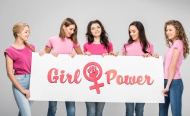 attractive young women holding large sign with girl power lettering isolated on grey clipart