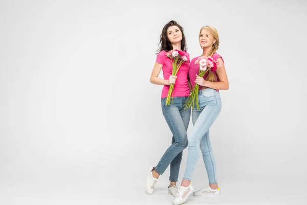 Mulheres Sorridentes Segurando Flores Sobre Fundo Cinza — Fotografia de Stock