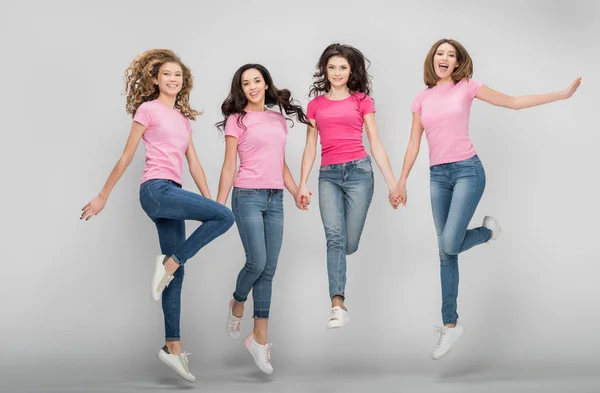 Chicas Felices Cogidas Mano Saltando Sobre Fondo Gris — Foto de Stock