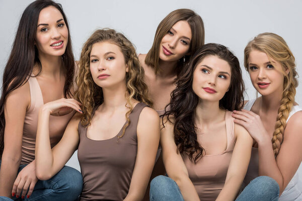 attractive young women support each other isolated on grey 