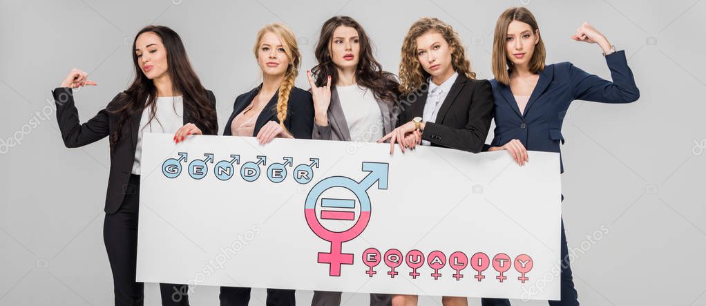 young businesswomen holding large sign with gender equality symbol isolated on grey 