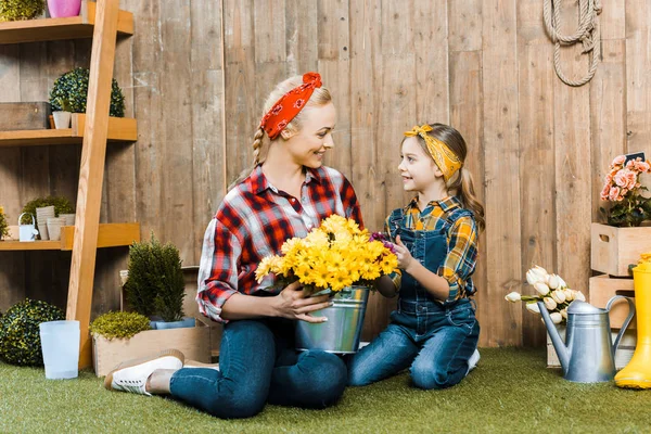 Happy Woman Looking Cute Daughter While Holding Flowers — Stock Photo, Image