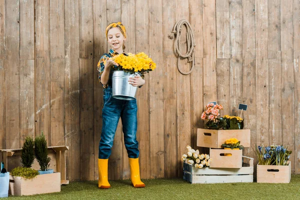 Criança Alegre Segurando Flores Balde Perto Caixas Com Plantas — Fotografia de Stock