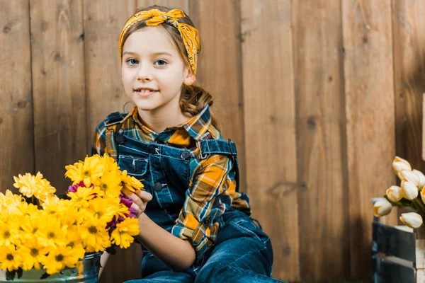 Entzückendes Kind Blickt Die Kamera Der Nähe Gelber Blumen — Stockfoto