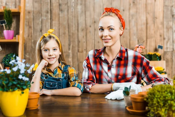 Fröhliche Mutter Sitzt Neben Tochter Der Nähe Von Pflanzen — Stockfoto