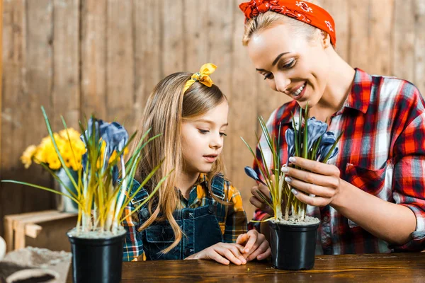 Feliz Madre Mirando Olla Con Flores Cerca Linda Hija — Foto de Stock