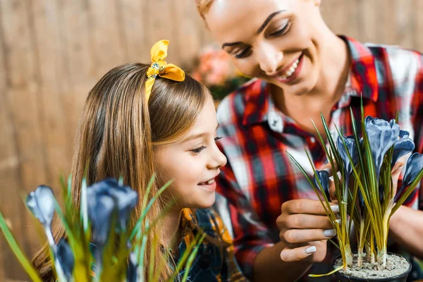 Mère Heureuse Touchant Fleurs Pot Près Fille Mignonne — Photo