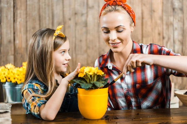 Dziecko Ogląda Szczęśliwą Matką Oddanie Gruntu Łopatą Doniczki Kwiatami — Zdjęcie stockowe