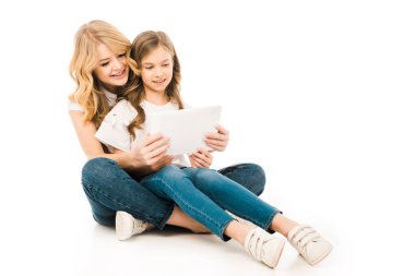 katta oturan ve beyaz arka plan üzerinde dizüstü kullanarak sevimli çocuk ile güzel anne