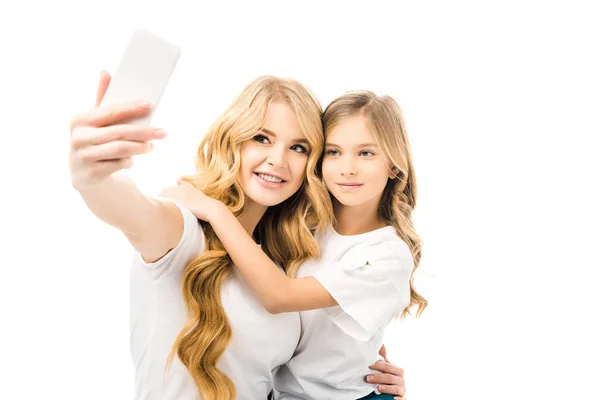 Sorridente Mãe Tomando Selfie Enquanto Abraçando Adorável Filha Isolada Branco — Fotografia de Stock