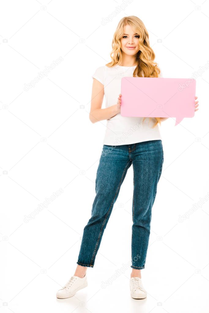 beautiful woman in white t-shirt and blue jeans holding pink speech bubble isolated on white