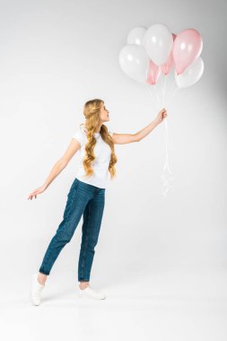 Beyaz arka plan üzerinde şenlikli pembe ve beyaz hava Balonlu güzel kadın