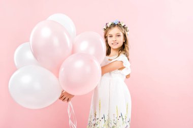 sevimli gülümseyen çocuk şenlikli hava balonları pembe bir arka plan üzerinde tutan