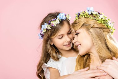 sevimli gülümseyen çocuk kucaklayan güzel mutlu anne pembe bir arka plan üzerinde