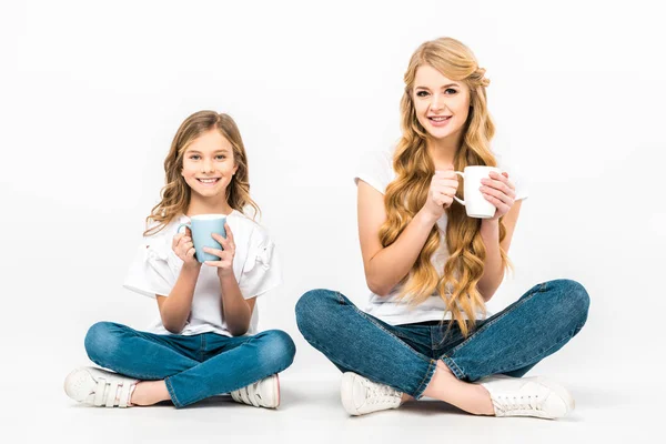 Lächelnde Mutter Und Tochter Mit Kaffeetassen Auf Dem Boden Sitzend — Stockfoto