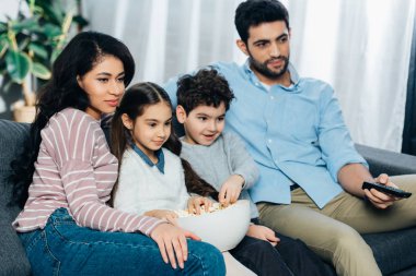 patlamış mısır kase ile evde TV izlerken mutlu İspanyol Aile
