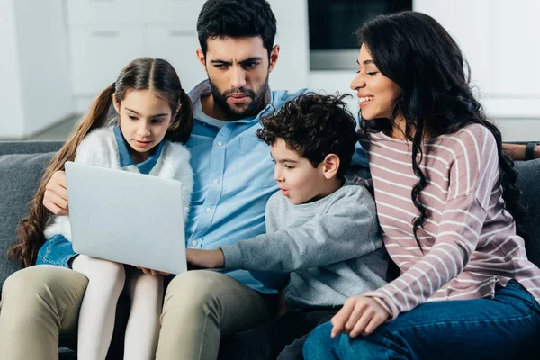 Familia Hispana Sonriente Sentada Sofá Mirando Computadora Portátil Casa —  Fotos de Stock