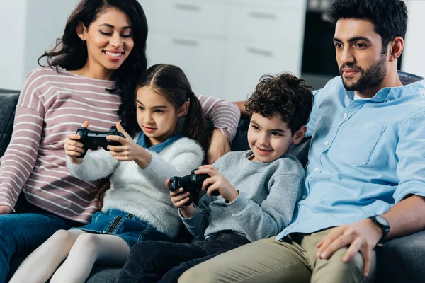 Padres Alegres Sentados Sofá Cerca Los Niños Jugando Videojuego Casa —  Fotos de Stock